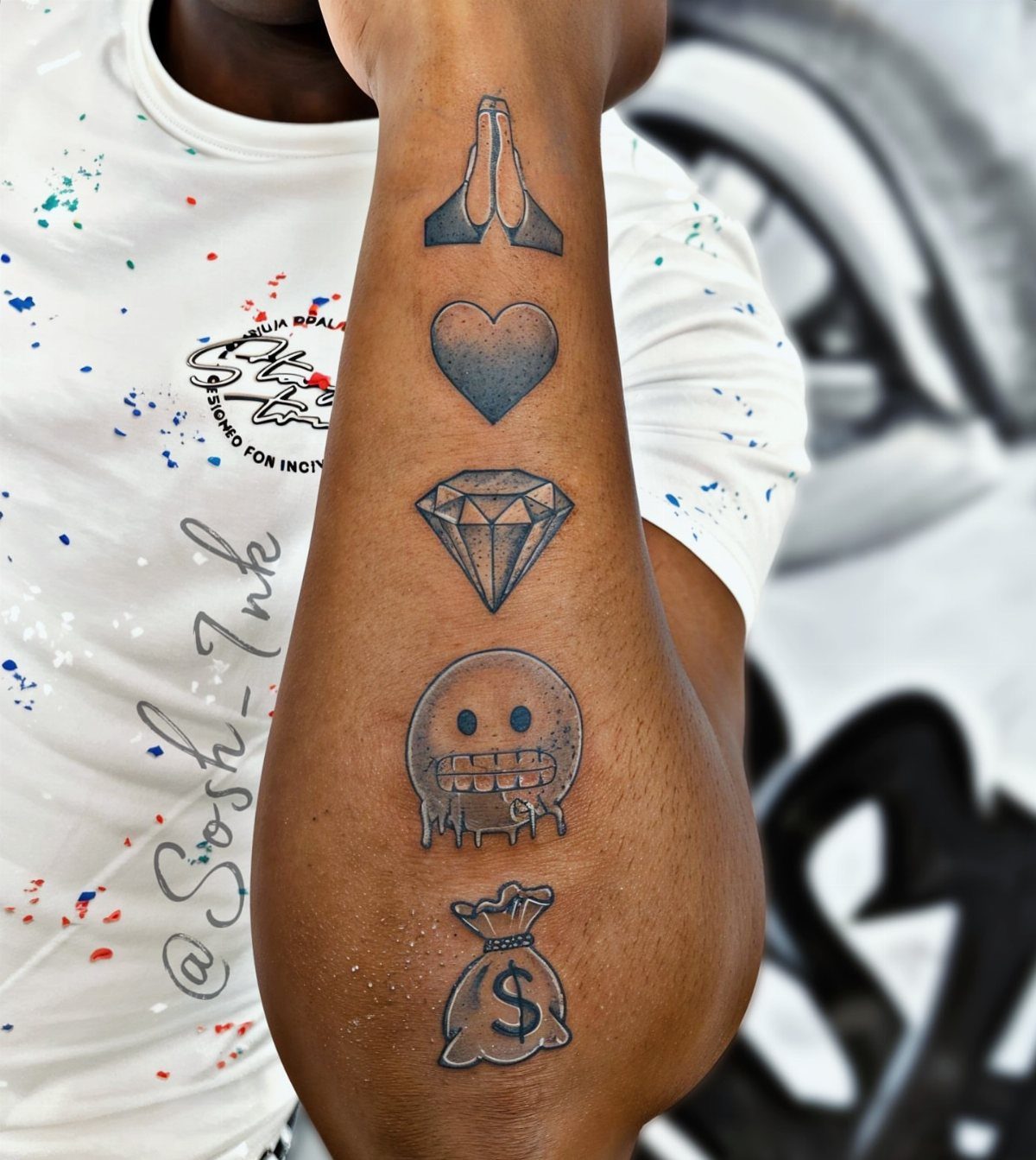 Forearm with a vertical series of five black and grey symbolic tattoos.