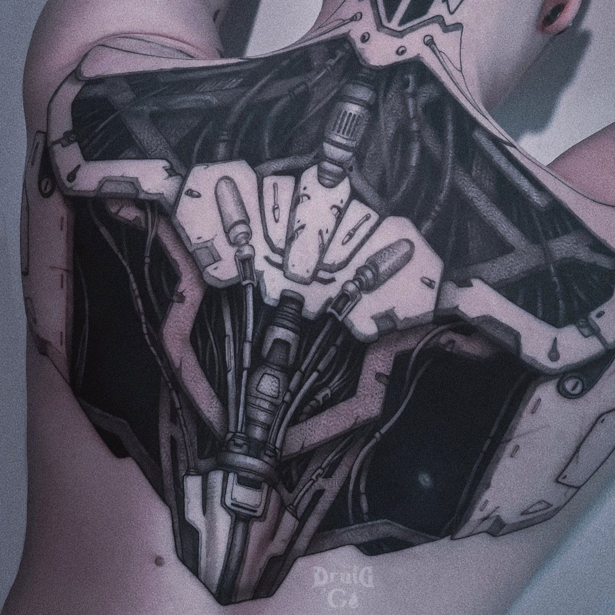 Biomechanical tattoo on a back featuring intricate mechanical parts and metallic plating.