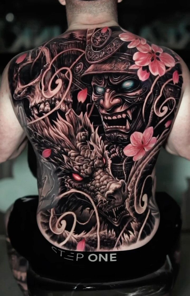 Japanese back piece tattoo featuring a dragon, samurai mask, and pink cherry blossoms.