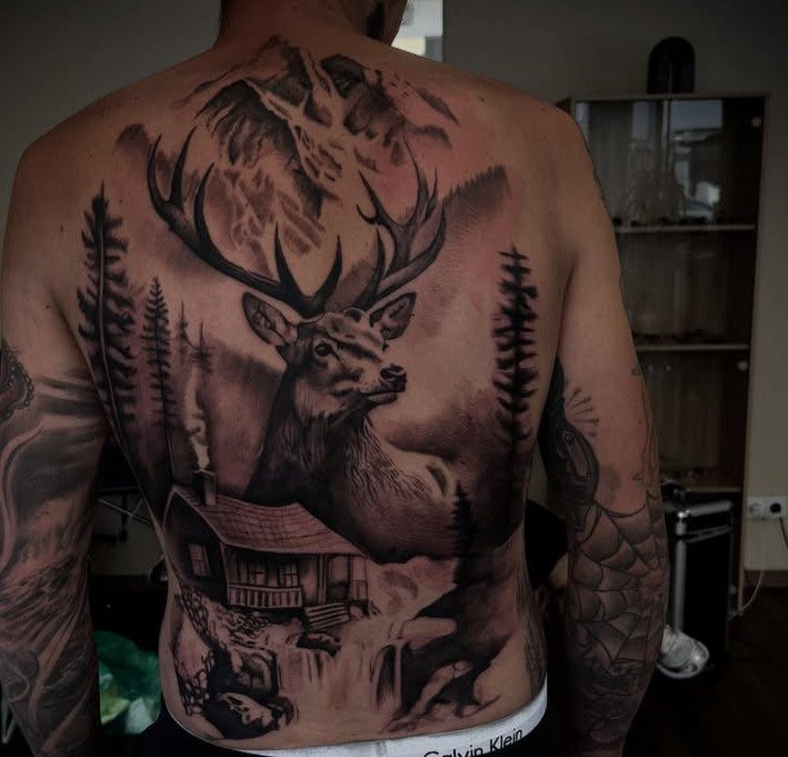 Stag and mountain landscape tattoo covering the entire back of a man.