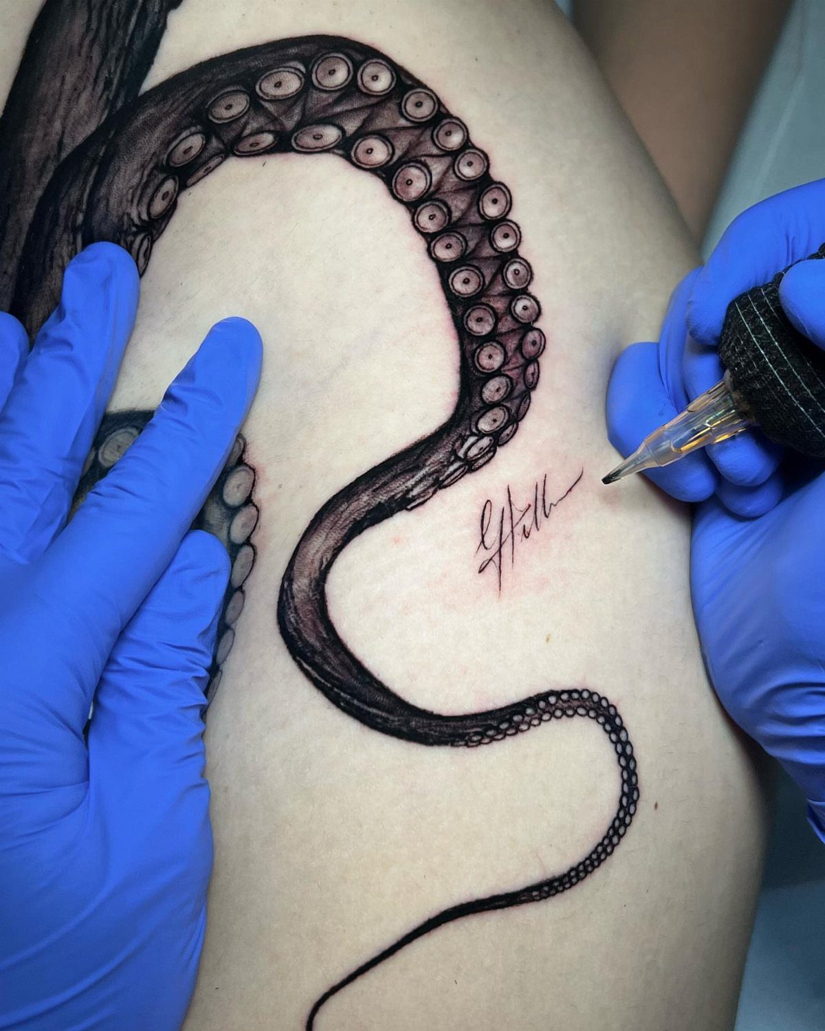 Back Ribs Tattoo Ideas: 7 Designs, Vines to Octopus 6 Octopus tentacle tattoo on a person's ribs being worked on by a tattoo artist.