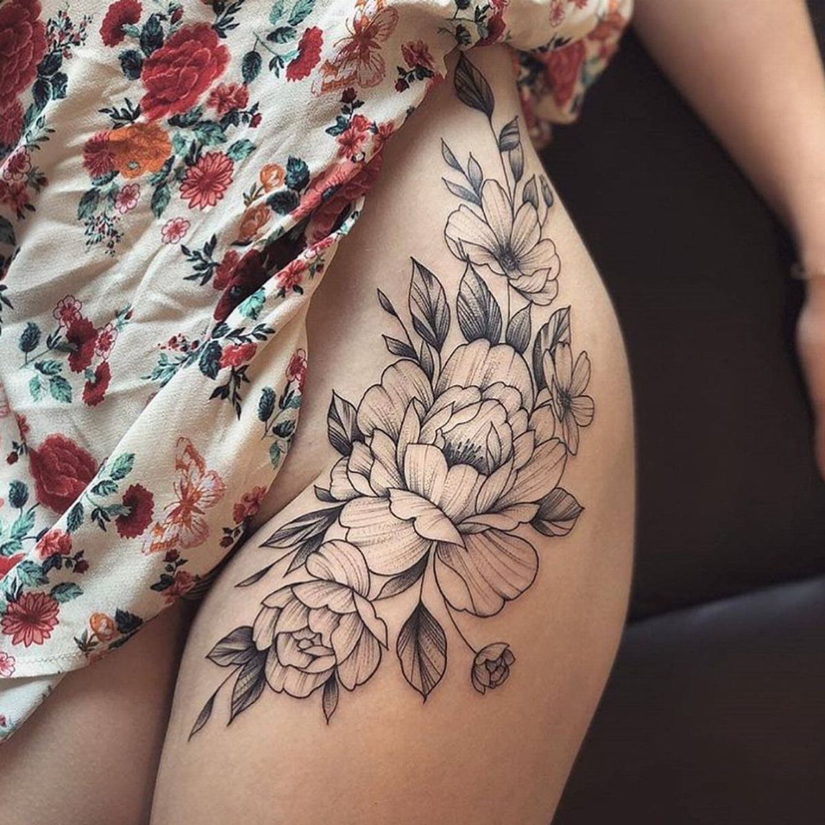 Floral peony tattoo on a person's hip and upper thigh area.