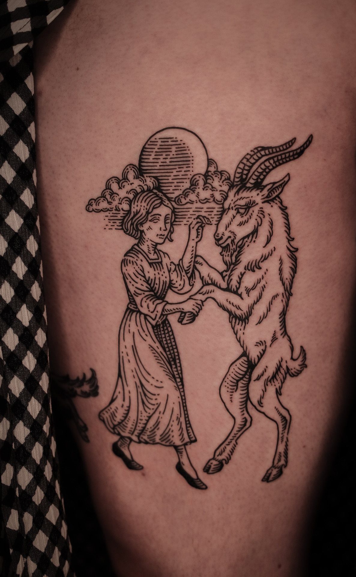 Illustrative blackwork tattoo of a woman dancing with a goat under a moon.