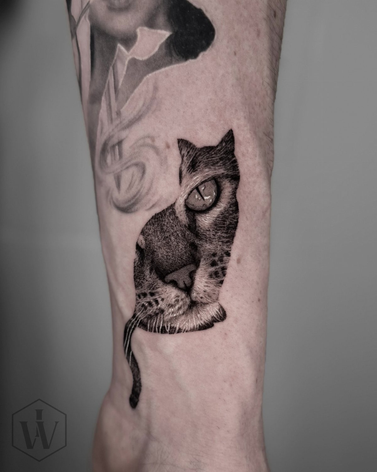Realistic black cat tattoo on skin showing detailed facial features and fur.