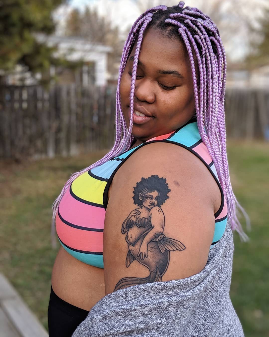 8 Black Mermaid Tattoo Ideas with Afro, Locs and Scales 1 Mermaid tattoo with a prominent afro on a person's upper arm.