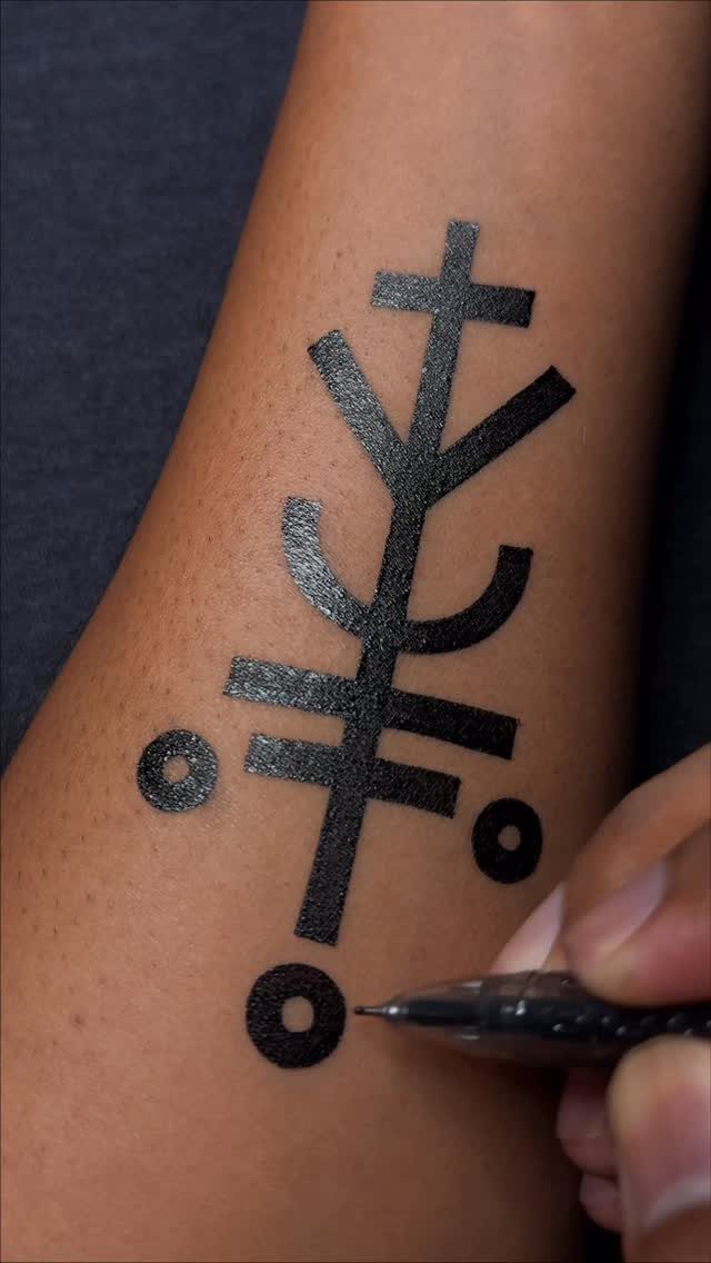 Black ink drawing of intersecting lines and circles on a person's arm.