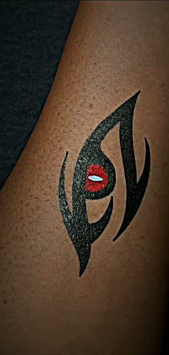 Stylized eye tattoo with black curved lines and a red pupil on skin