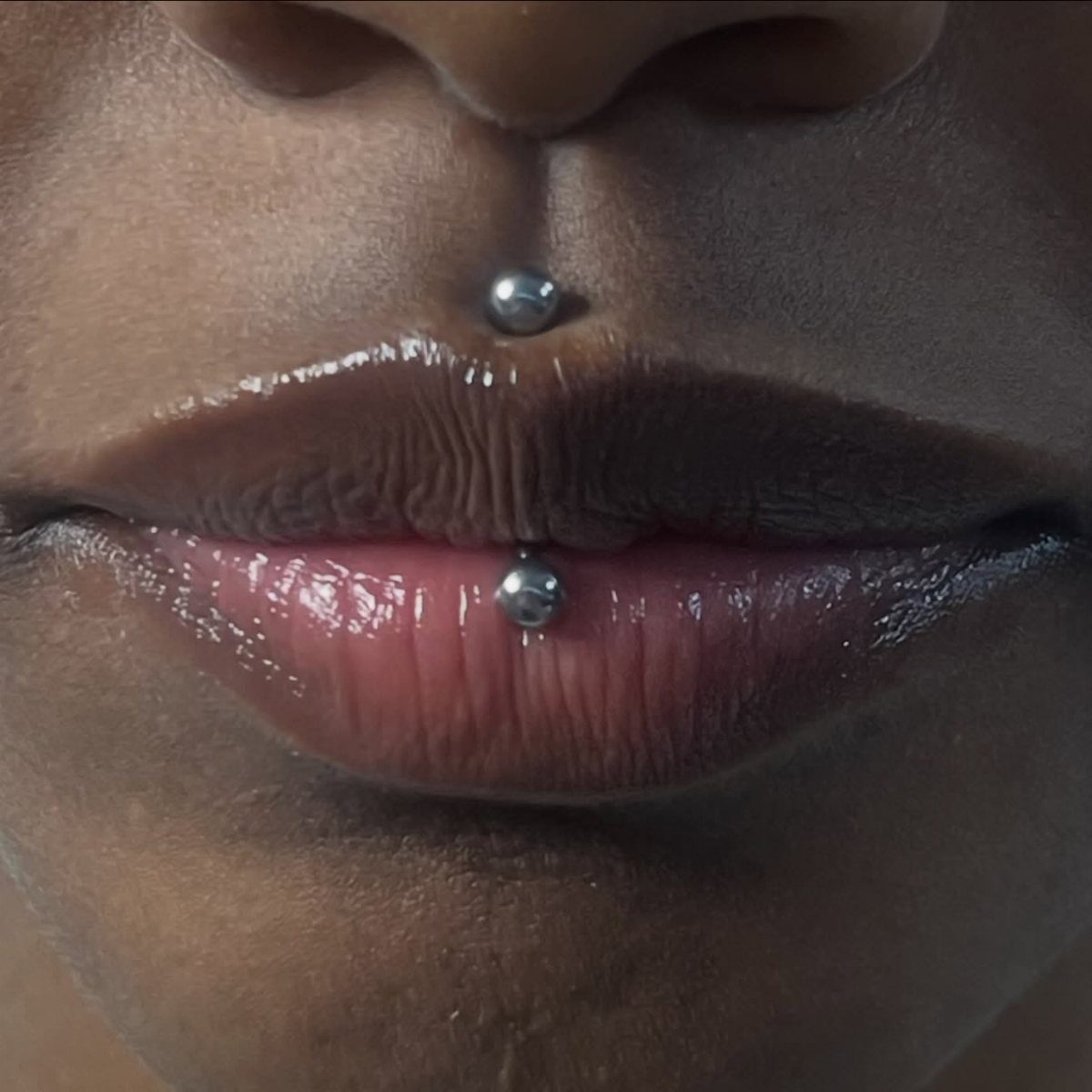 Center Lip Piercing Ideas: 7 Styles to Consider 4 Lips with a vertical Jestrum piercing featuring silver beads above and below.