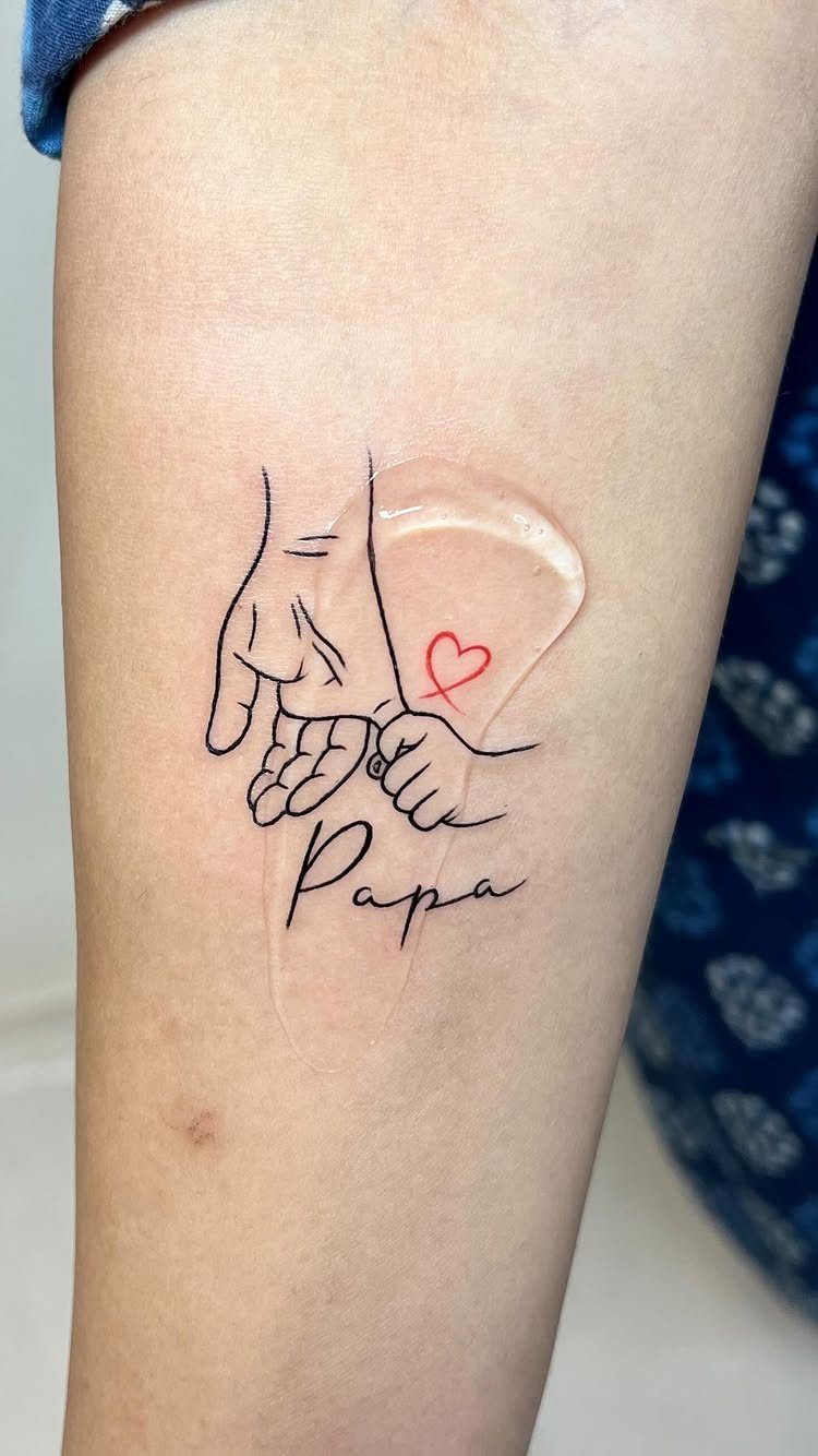 Tattoo of a father and child holding hands with the word Papa.