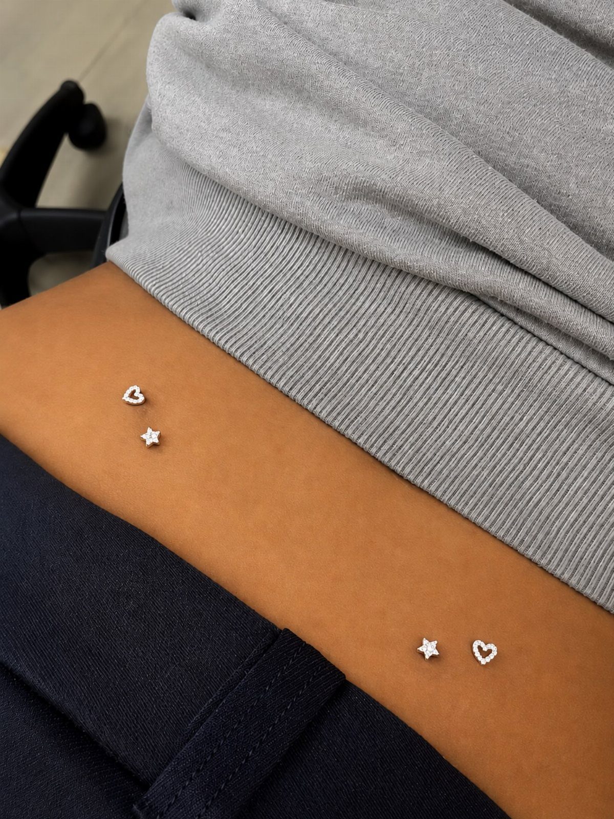 Dermal Piercing for Back Dimples: 7 Ideas and Jewelry 2 Dermal piercings with heart and star studs in the lower back dimples