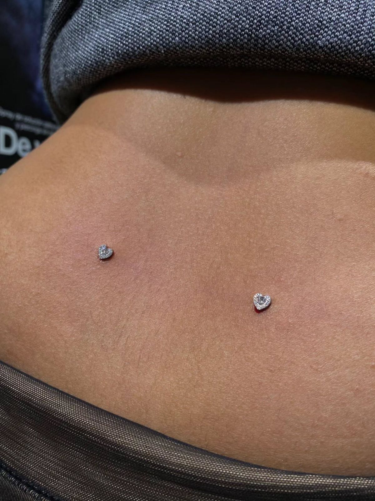 Dermal Piercing for Back Dimples: 7 Ideas and Jewelry 6 Two heart-shaped dermal piercings located in the dimples of a person's lower back.