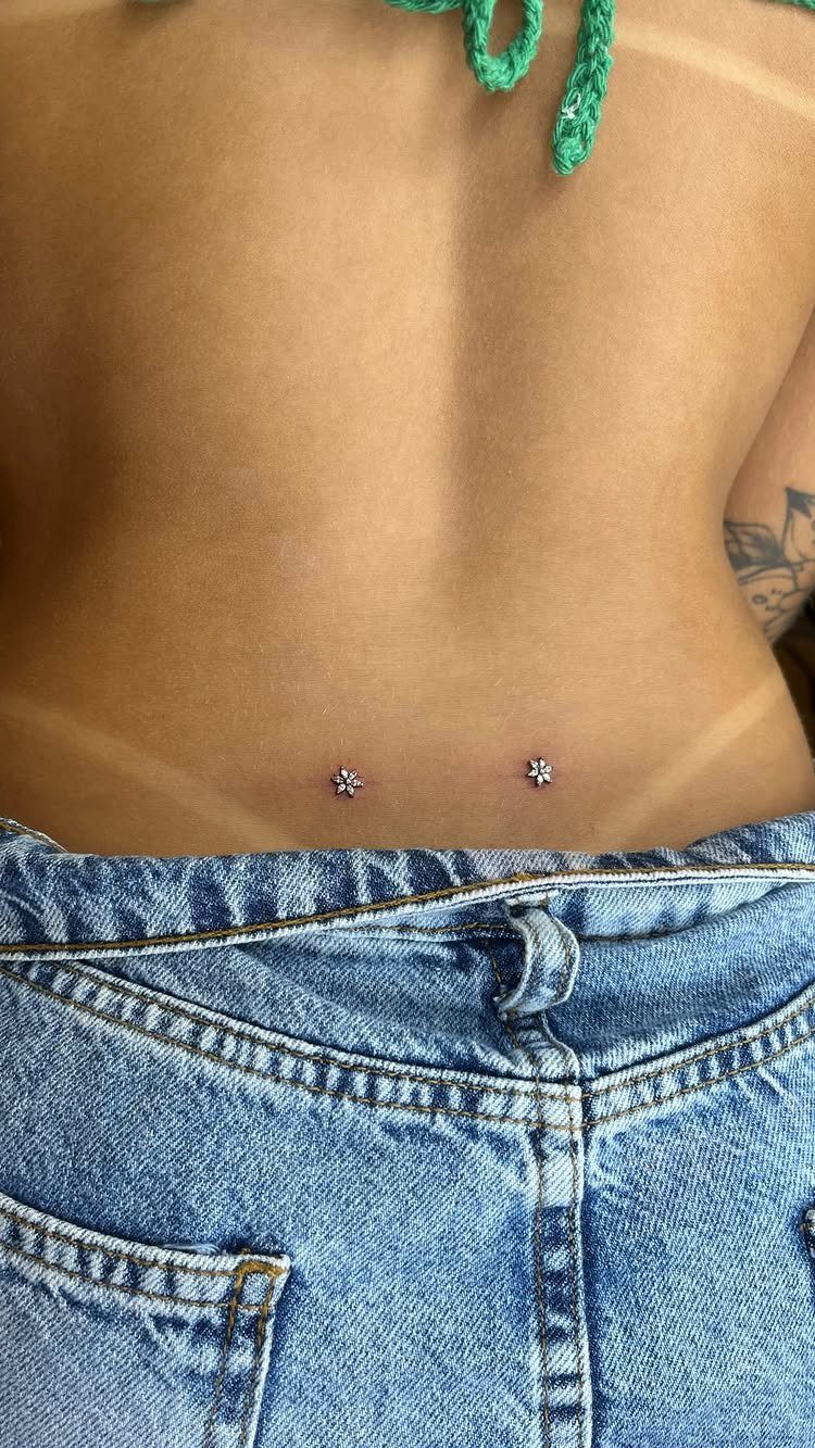 Dermal Piercing for Back Dimples: 7 Ideas and Jewelry 4 Two silver star dermal piercings in the dimples of a person's lower back