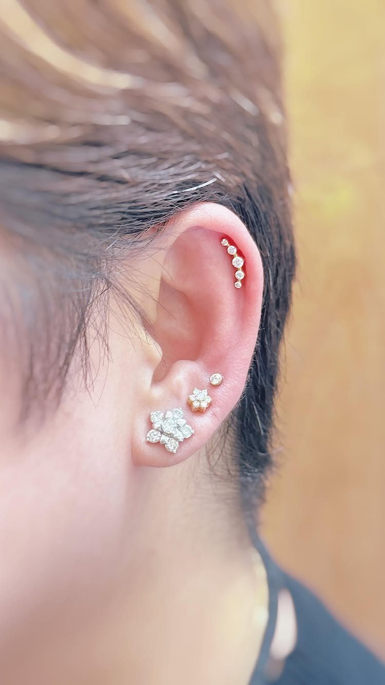 12 Ear Piercing Combo Ideas for Every Style 12 Ear with a diamond flower statement lobe and a vertical flat piercing stack.