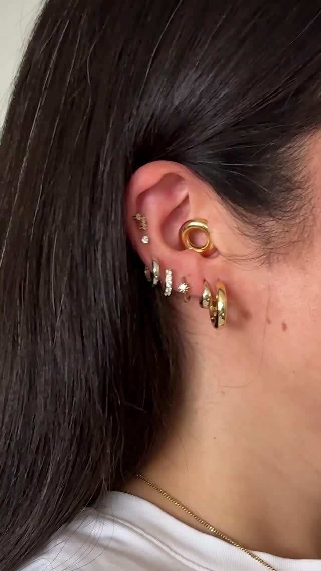 12 Ear Piercing Combo Ideas for Every Style 11 Ear with gold conch hoop, tragus stud, and a gradient of lobe earrings.