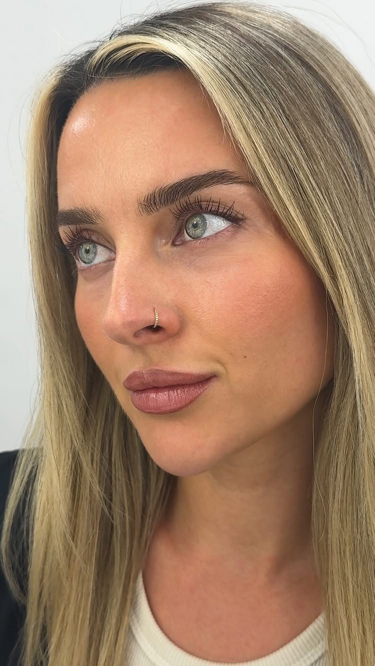 Woman with blonde hair and a small gold nostril piercing in her nose.