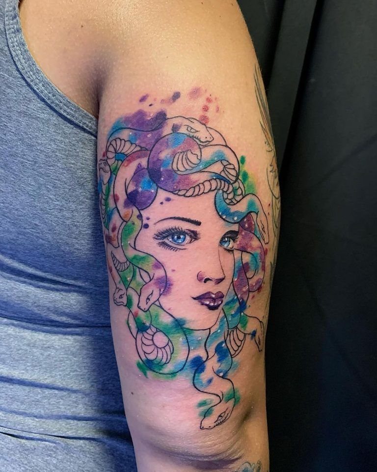 Medusa tattoo on an arm with vibrant purple and blue watercolor splashes
