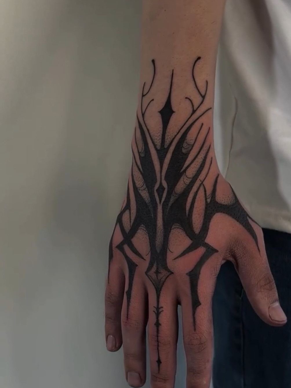 15 Hand Pen Tattoo Ideas for Spider Webs, Flowers and More 4 Hand with a symmetrical black ink geometric and abstract tattoo design