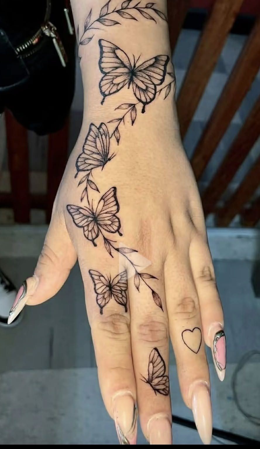 15 Hand Pen Tattoo Ideas for Spider Webs, Flowers and More 15 Hand and wrist with black ink tattoos of butterflies and leafy branches.