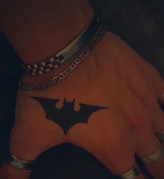 15 Hand Pen Tattoo Ideas for Spider Webs, Flowers and More 7 Batman bat-symbol tattoo on the back of a hand with silver jewelry