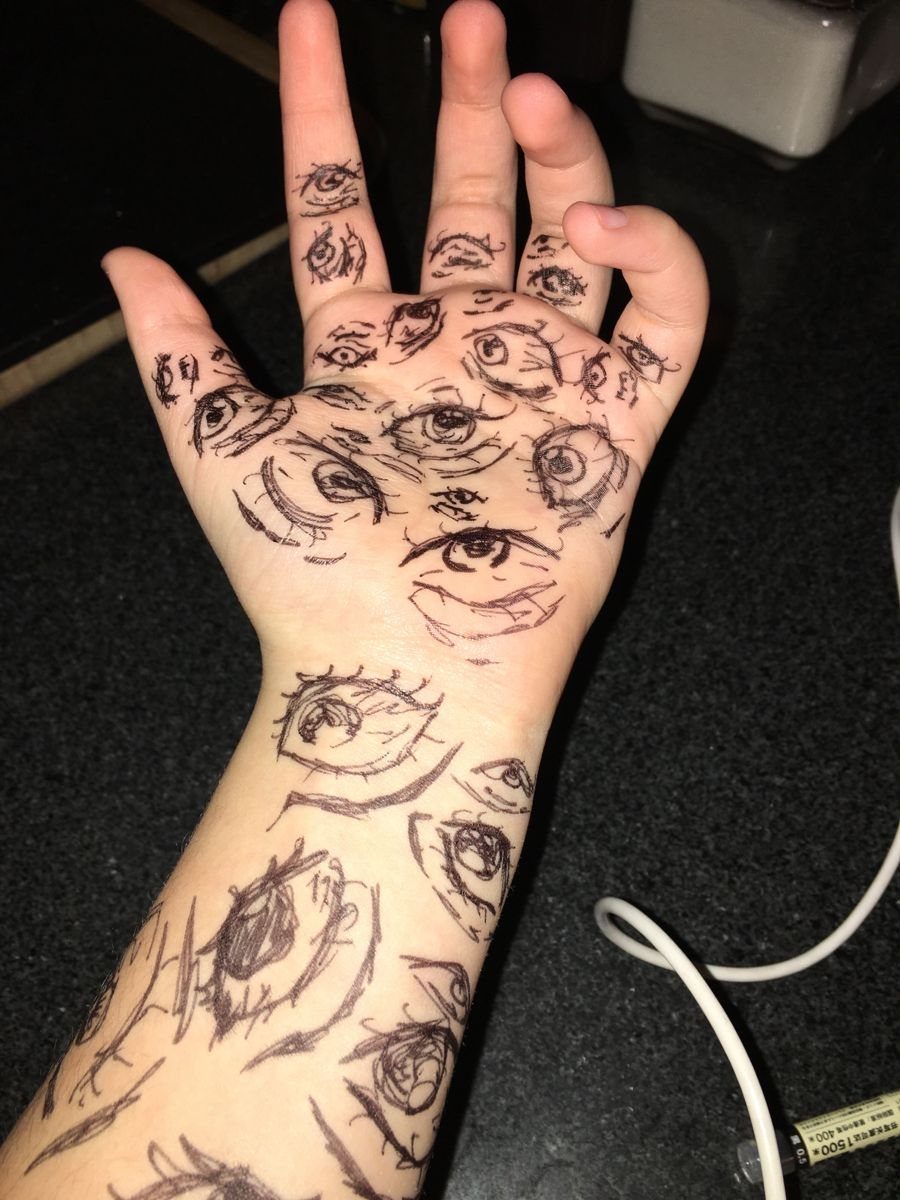 15 Hand Pen Tattoo Ideas for Spider Webs, Flowers and More 3 Hand and wrist covered in black ink drawings of multiple stylized eyes.
