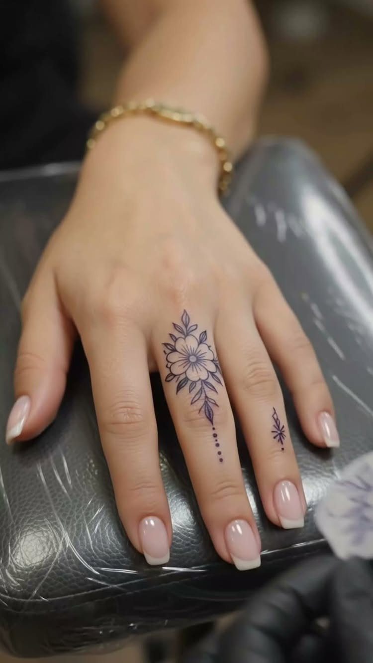 15 Hand Pen Tattoo Ideas for Spider Webs, Flowers and More 2 Hand with a black ink floral tattoo on the middle finger and ring finger.