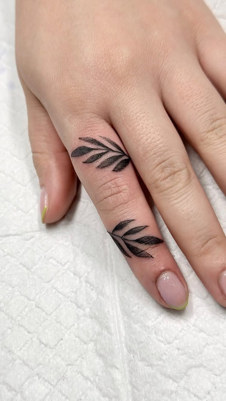 15 Hand Pen Tattoo Ideas for Spider Webs, Flowers and More 10 Leafy branch tattoos in black ink on the fingers of a hand.