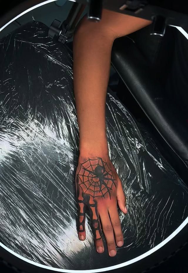 15 Hand Pen Tattoo Ideas for Spider Webs, Flowers and More 1 Hand with a spider web and spider tattoo and skeletal finger designs.