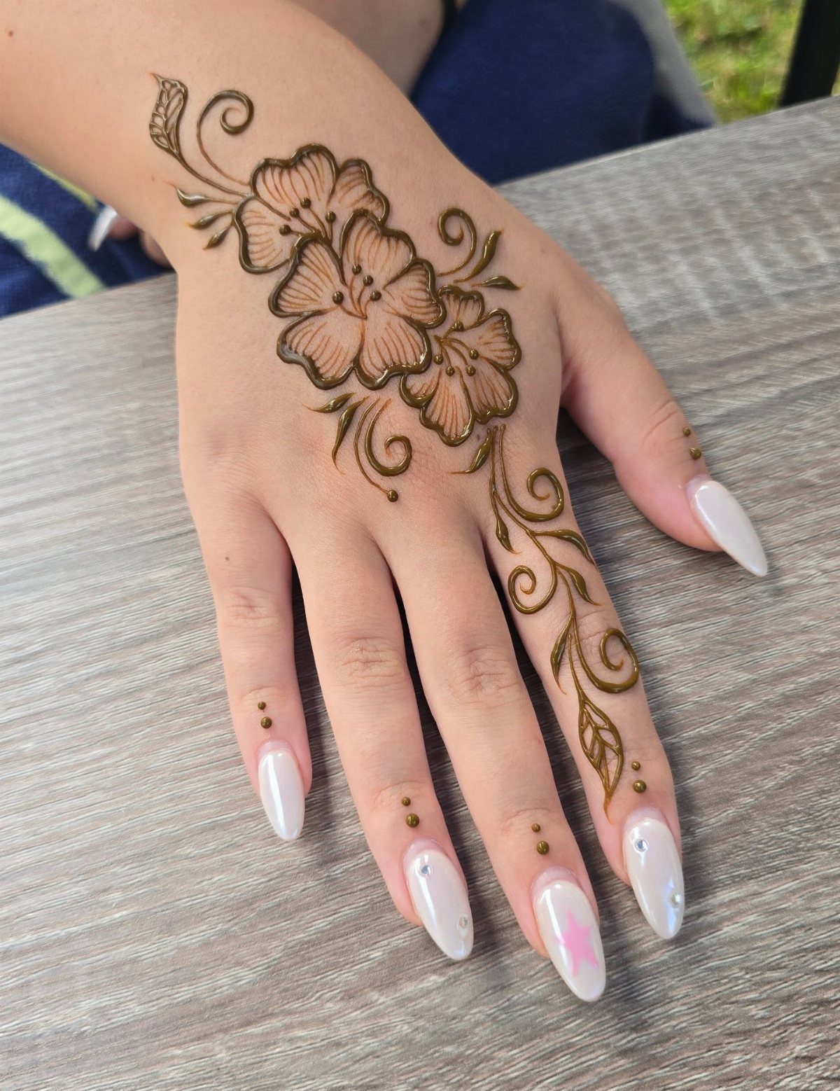 6 Hand Tattoo Henna Style Ideas for Every Taste 1 Henna tattoo of brown flowers and vines on the back of a hand