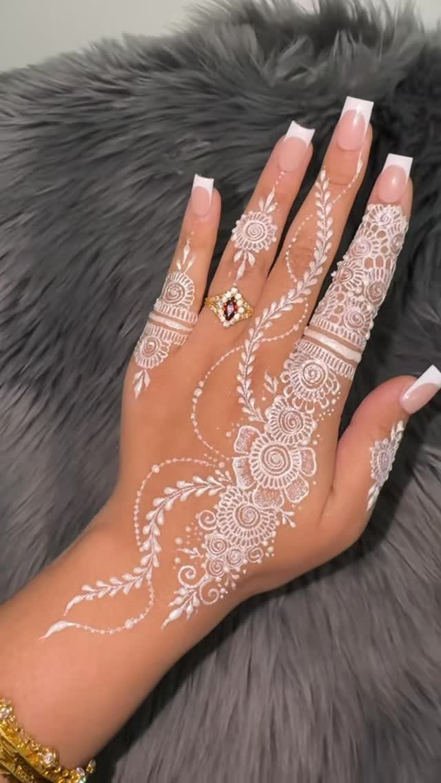 6 Hand Tattoo Henna Style Ideas for Every Taste 5 Hand with intricate white henna floral patterns and long white manicured nails.