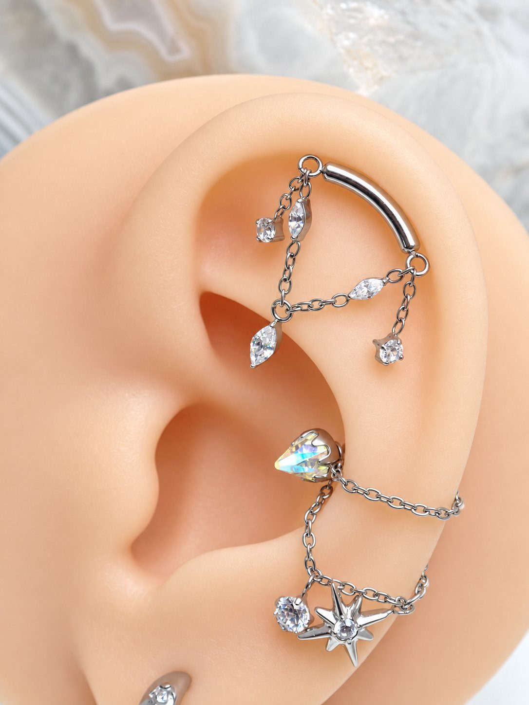 Hanging Ear Piercing Ideas: 6 Chain, Pearl and Star Styles 3 Silver curved barbell in helix with hanging chains and marquise crystals on ear model