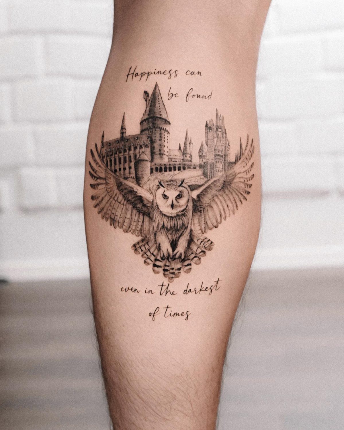 Owl and Hogwarts castle tattoo with a quote on a person's leg