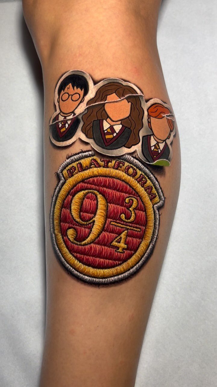 Platform 9 3/4 circular sign tattoo with cartoon characters on a person's arm.
