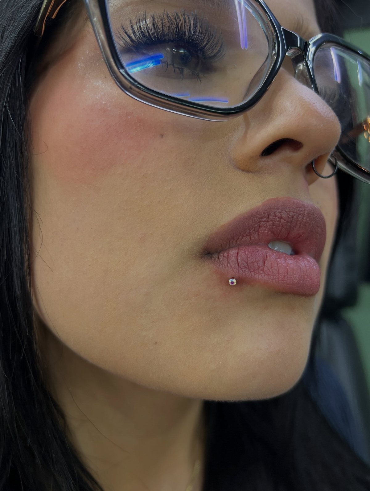 Lip Piercings for Small Lips: 7 Styles to Consider 2 Person with a classic labret piercing centered below the bottom lip and glasses.