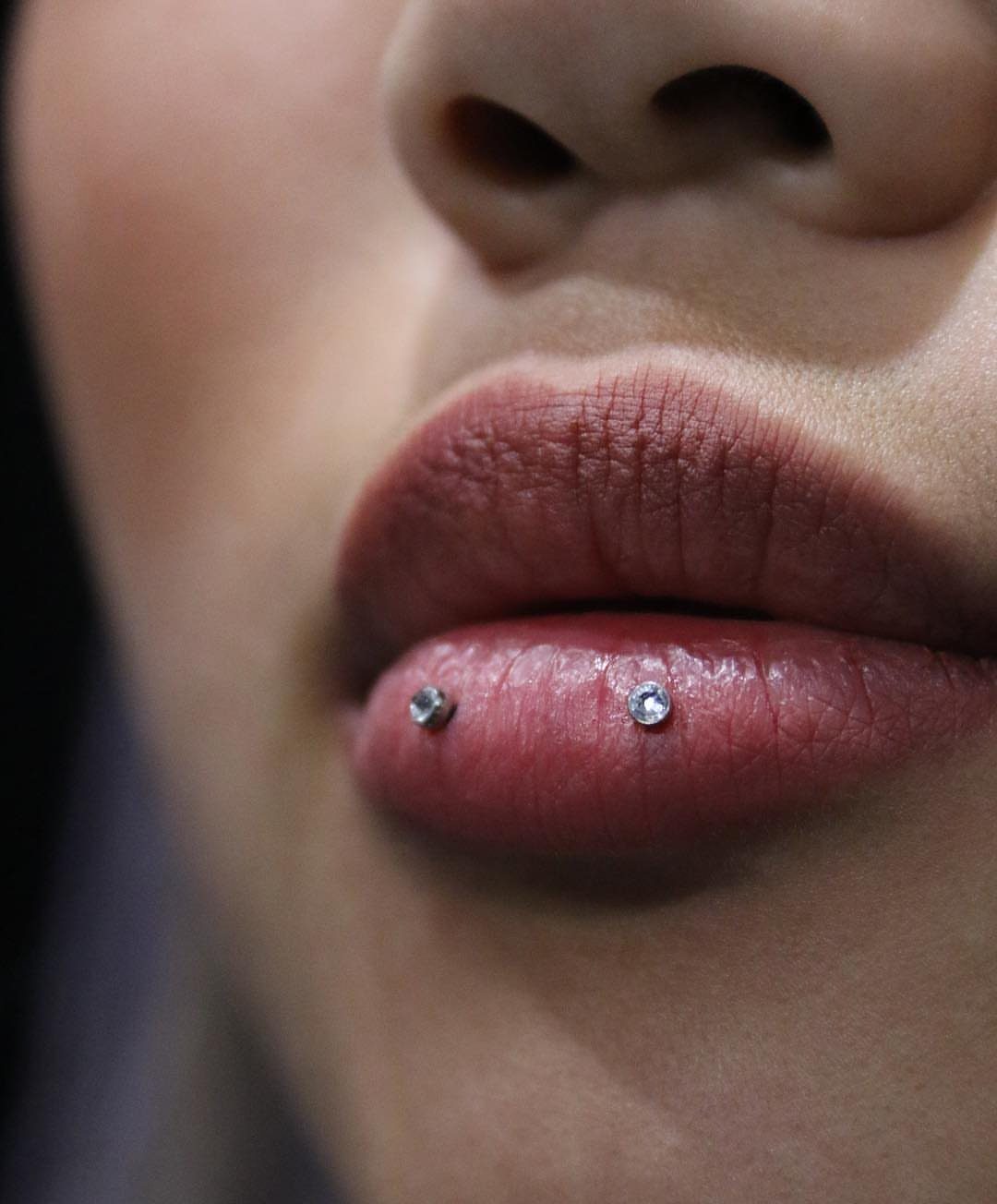 Lip Piercings for Small Lips: 7 Styles to Consider 3 Lower lip with two clear gemstone studs in a horizontal piercing.