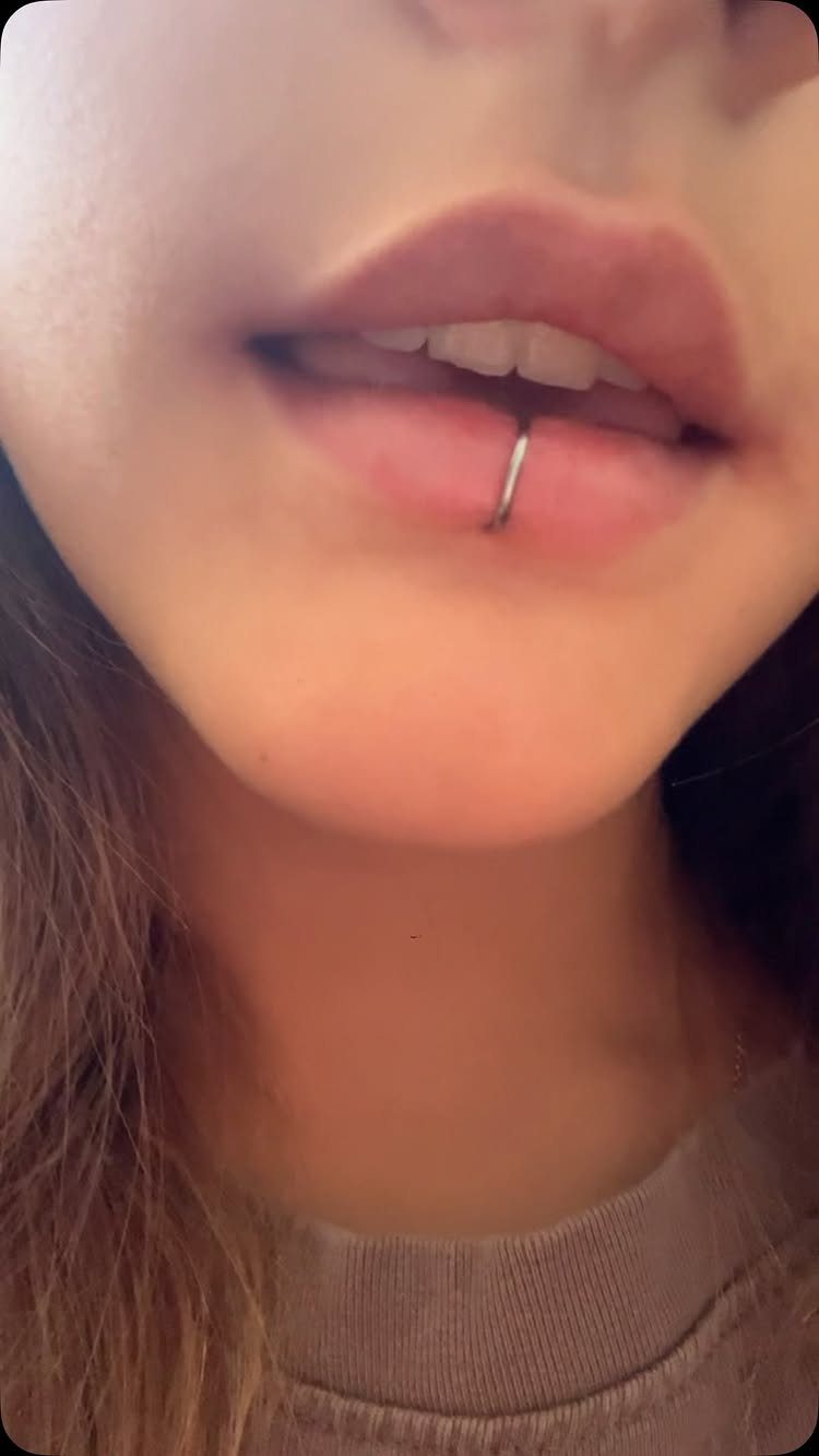 Lip Piercings for Small Lips: 7 Styles to Consider 4 Lower lip with a vertical labret piercing and silver metal barbell.