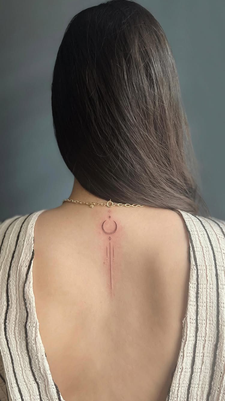 Minimalist Fine Line Tattoo Ideas: 9 Styles to Consider 5 Fine line geometric tattoo of a crescent and vertical line on a woman's back