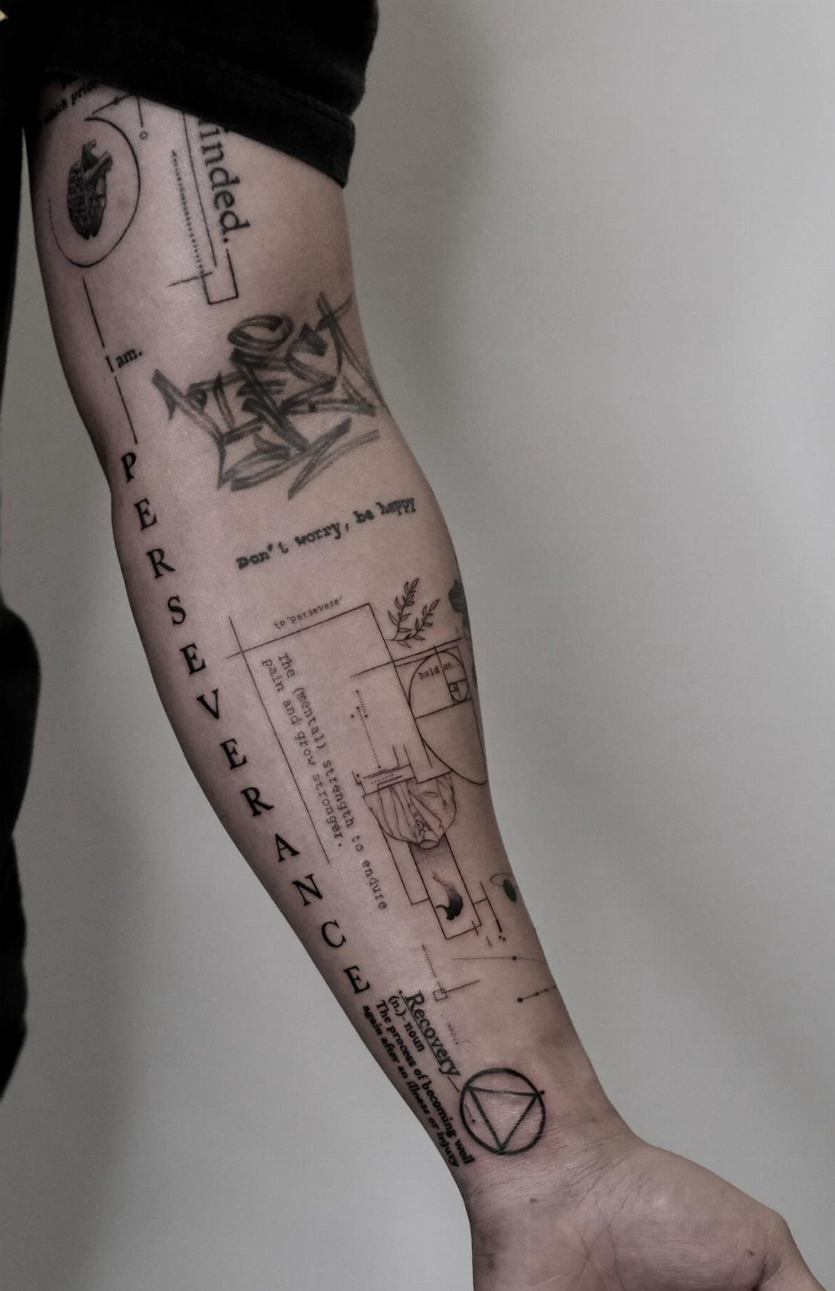 Minimalist Fine Line Tattoo Ideas: 9 Styles to Consider 7 Forearm with various black ink tattoos including the word perseverance and geometric shapes.