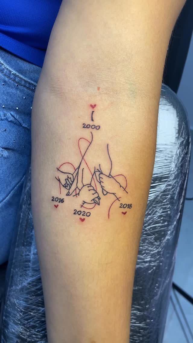 Red line art tattoo of four hands holding each other with dates and hearts.