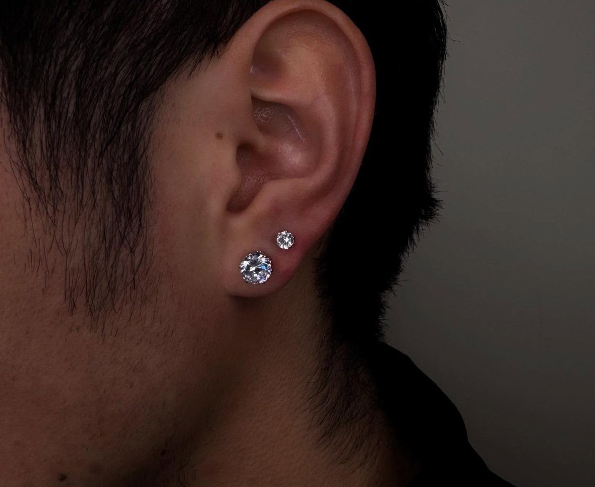 Ear lobe with two clear diamond stud piercings in a layered arrangement