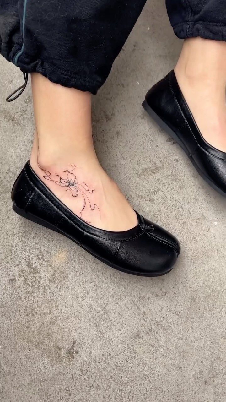 Spider tattoo on the ankle and top of a foot wearing black flats