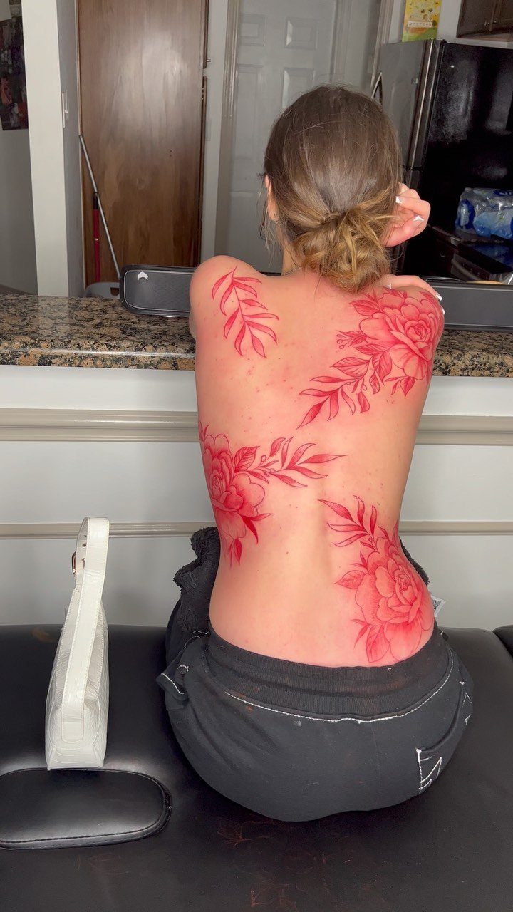Woman with a large red floral tattoo covering her entire back