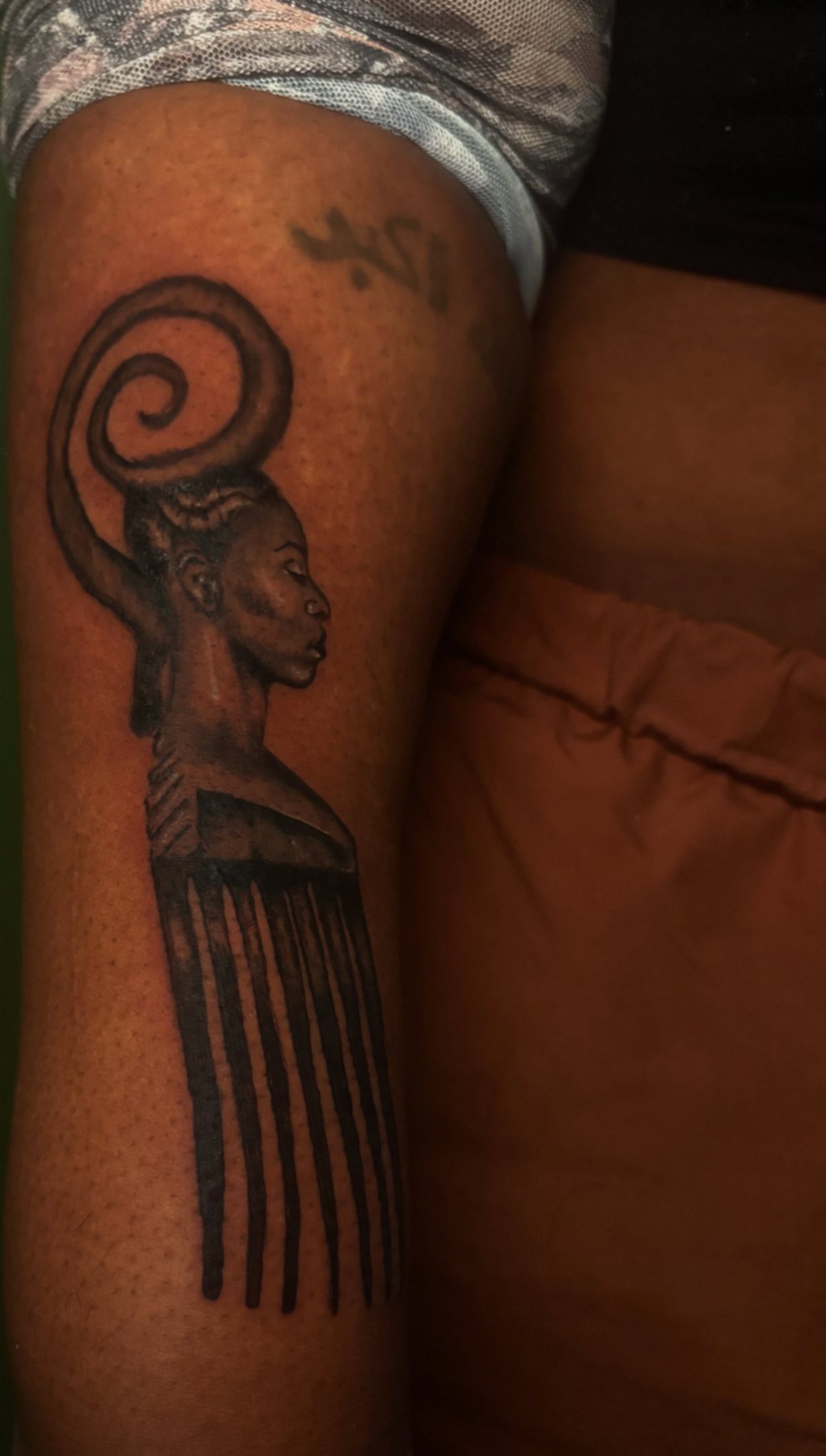 8 Pro Black Tattoos Ideas for Bold, Meaningful Ink 2 Tattoo of a woman's profile merging into a black ink hair pick silhouette.