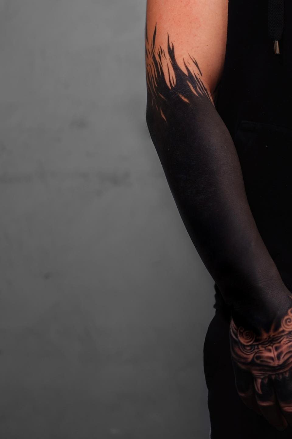 8 Pro Black Tattoos Ideas for Bold, Meaningful Ink 1 Solid black ink tattoo covering a forearm from wrist to elbow.