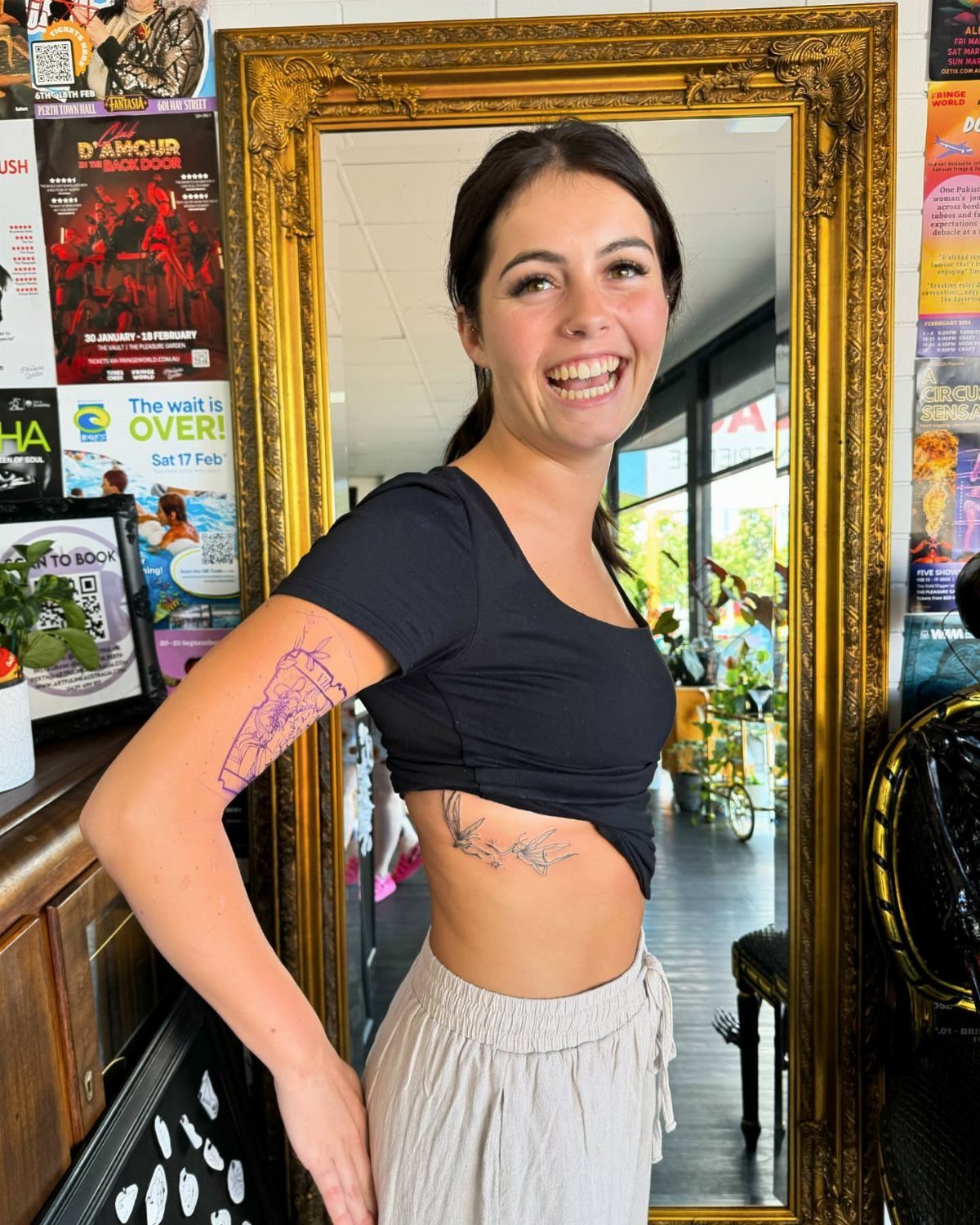 Rib Tattoos for Women: 9 Floral, Celestial and Script Ideas 8 Woman smiling with a small bird tattoo on her right ribcage.