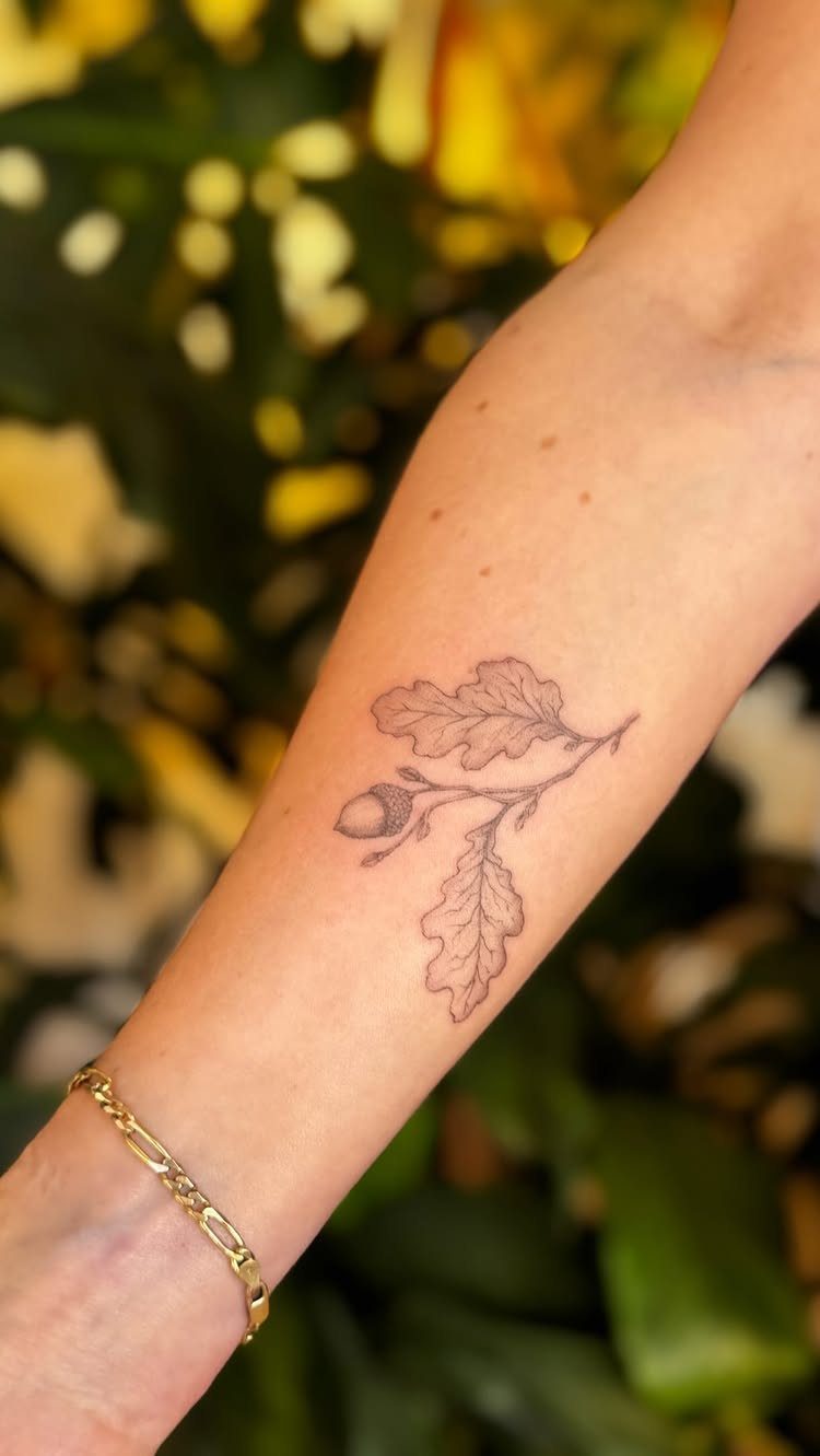 26 Self Tattoo Ideas for Simple, Meaningful Ink 20 Acorn and oak leaf tattoo on a person's forearm with a gold bracelet.