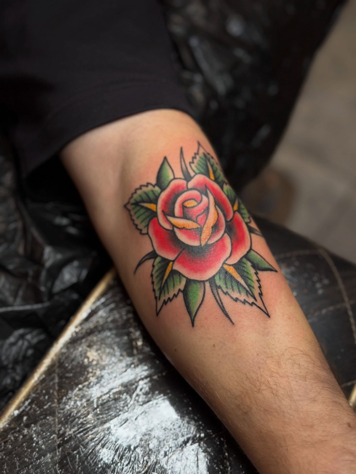 26 Self Tattoo Ideas for Simple, Meaningful Ink 12 Red rose tattoo with green leaves on a person's forearm in traditional style.