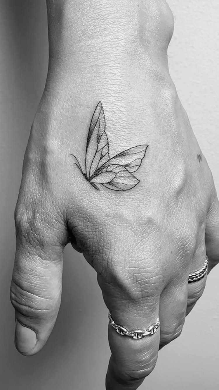 26 Self Tattoo Ideas for Simple, Meaningful Ink 2 Butterfly tattoo on the back of a hand with silver chain rings.