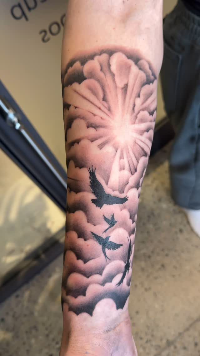 26 Self Tattoo Ideas for Simple, Meaningful Ink 21 Forearm tattoo of fluffy clouds with a radiating sun and flying birds.