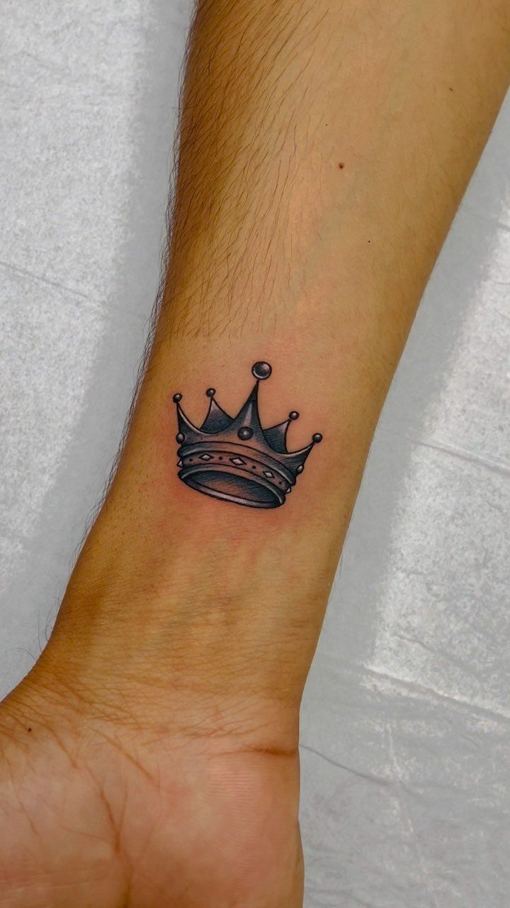 26 Self Tattoo Ideas for Simple, Meaningful Ink 17 Small black and grey crown tattoo on a person's inner wrist
