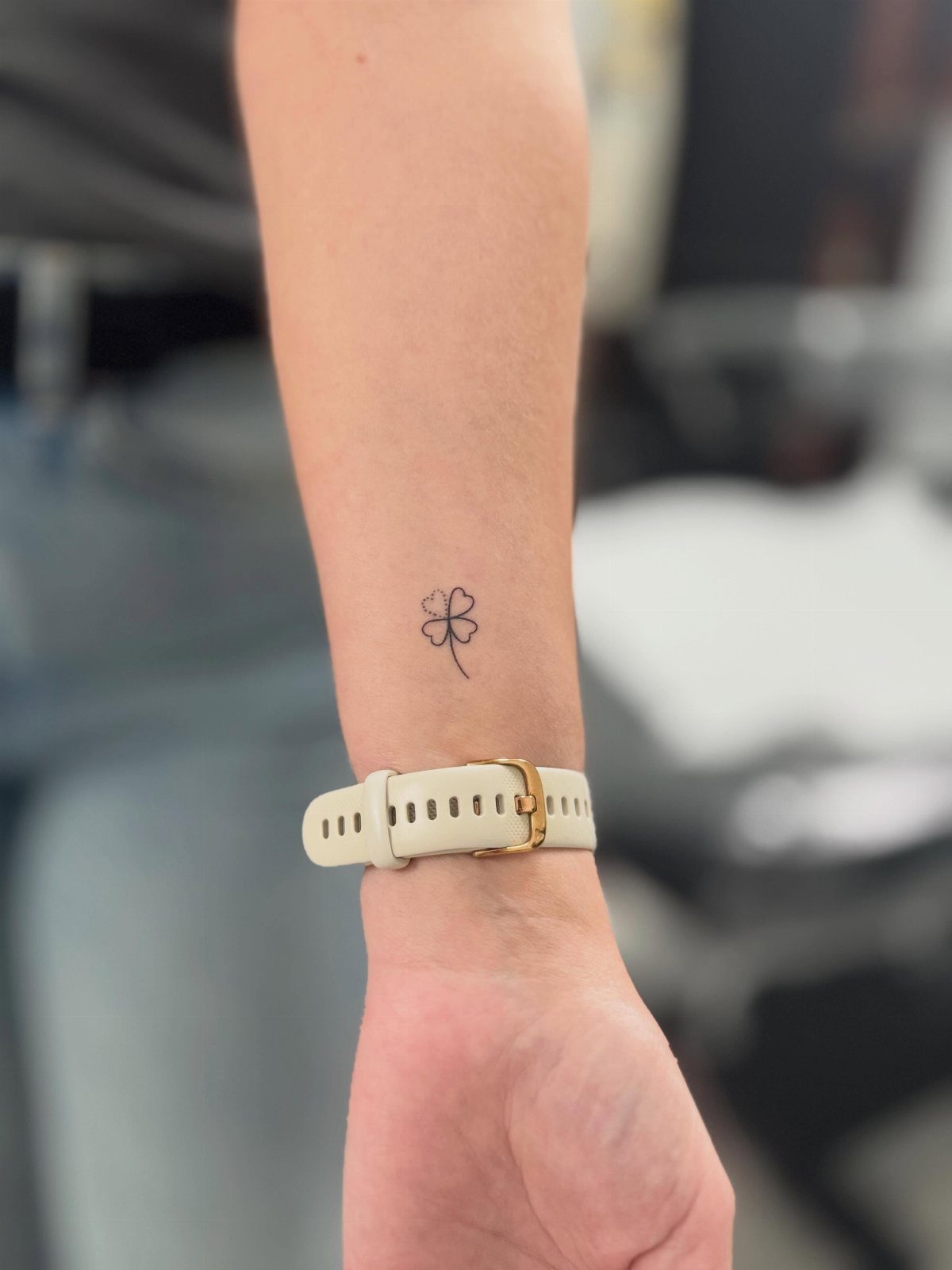 26 Self Tattoo Ideas for Simple, Meaningful Ink 24 Small black four-leaf clover tattoo on a person's inner wrist with a white watch.